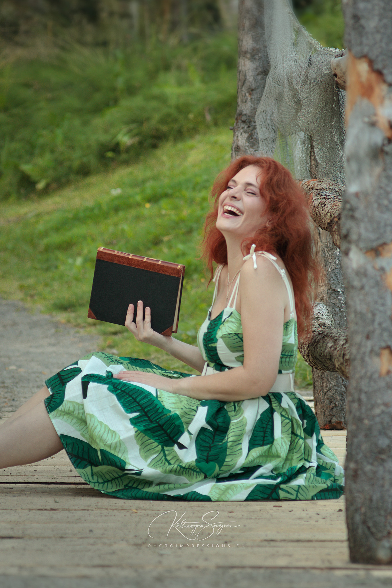 Woman in a long green dress posing among green foliage in Iceland.