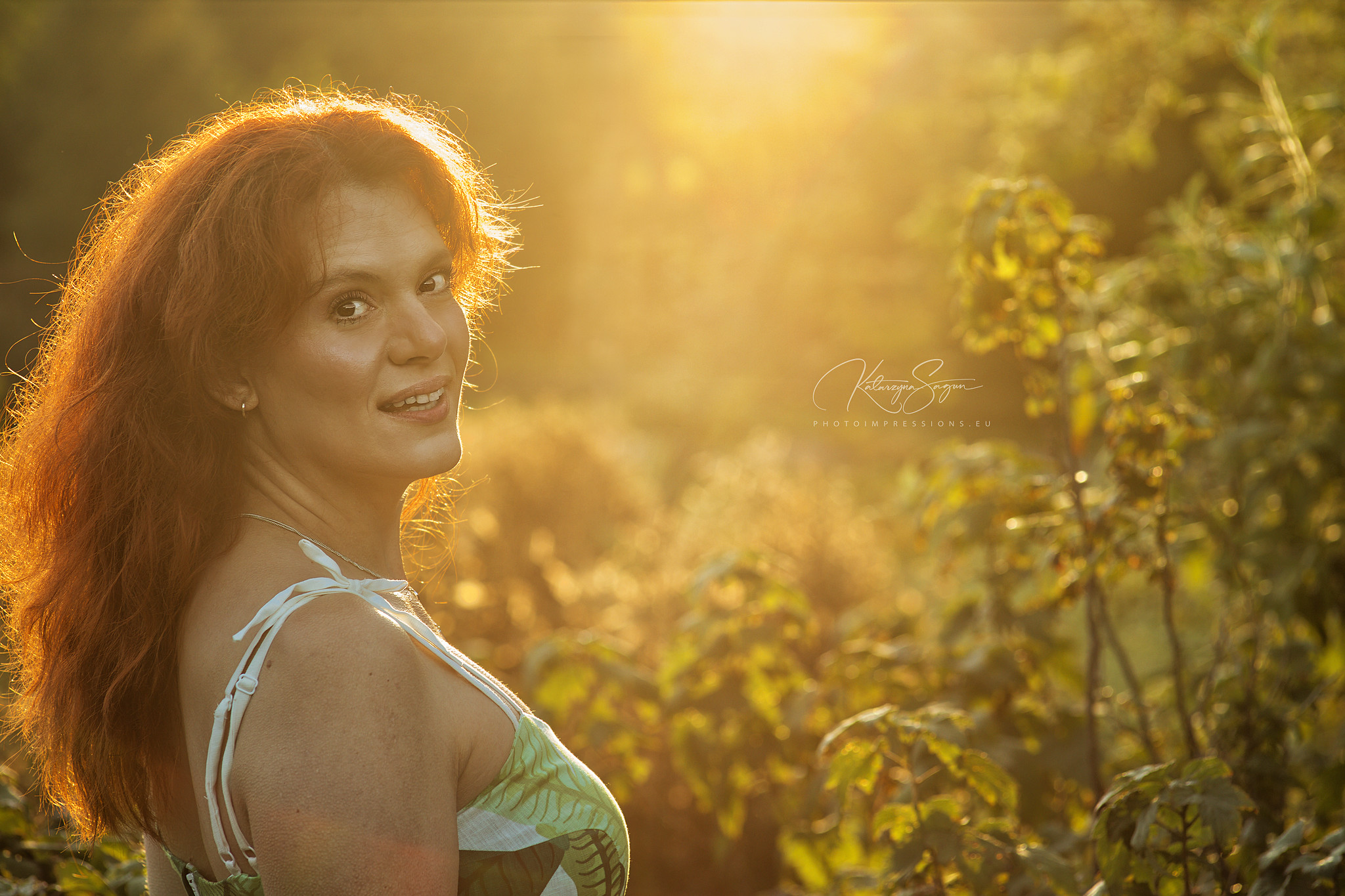Woman illuminated by strong, golden hour sunlight in the Icelandic landscape.